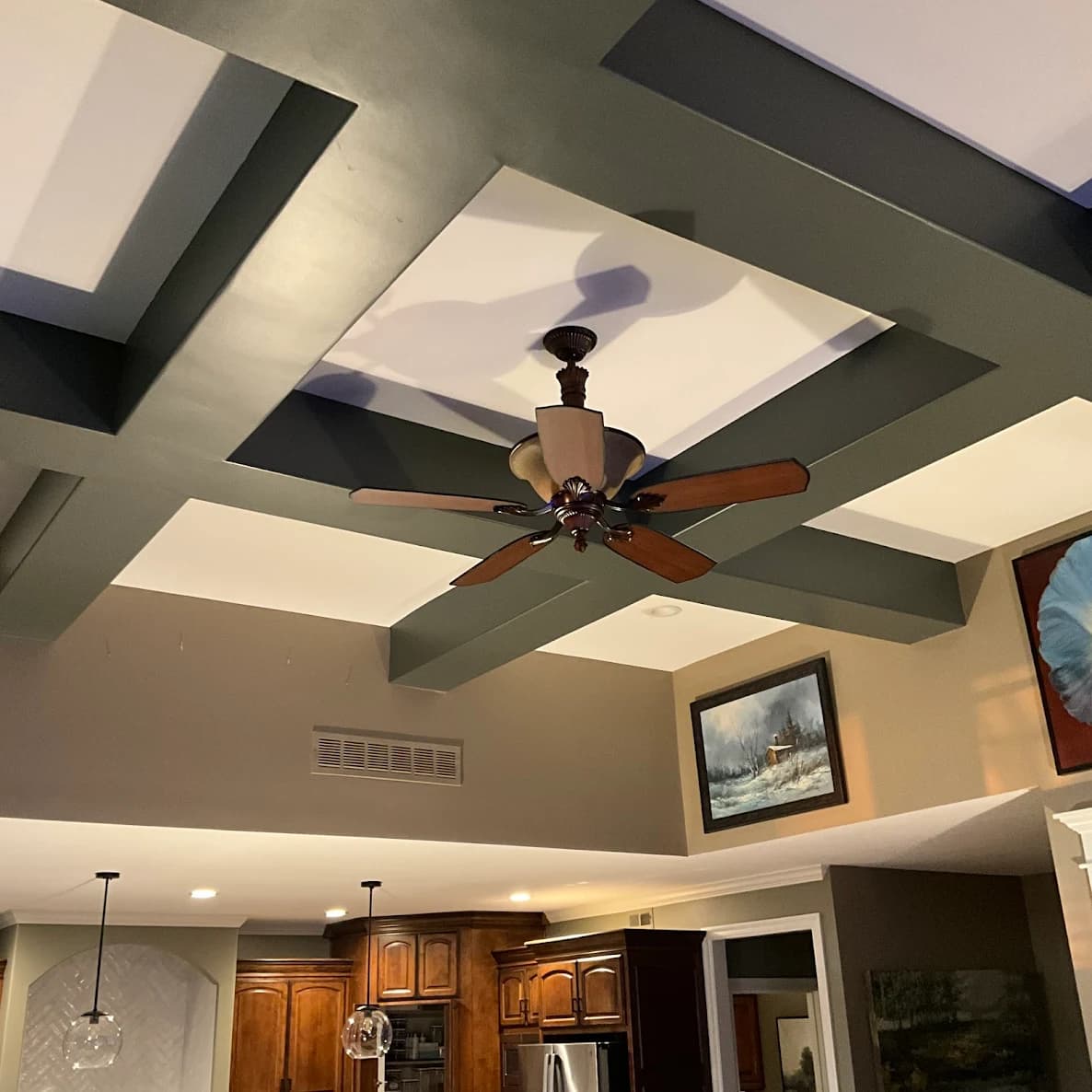 This is an image from Mission Painting and Home Improvements. The image shows an interior ceiling with painted beams in dark gray and contrasting white panels.