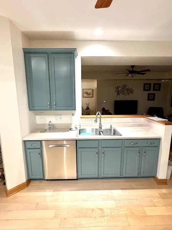 Kitchen cabinet refinishing by Eclips3 Kitchens LLC in Orland Park, IL. The image shows a kitchen sink base with muted blue cabinets.