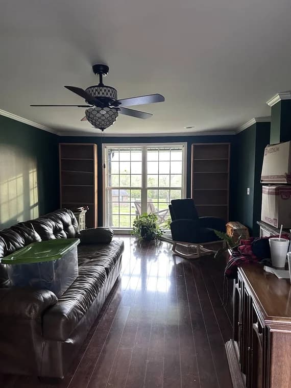 Epic Painting painting project in Lewisburg, Tennessee. The image shows a living room with dark painted walls and white trim.