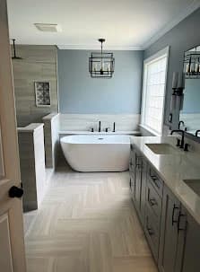Bathroom painting project by Perfection Painting Pros in Charlotte, NC. The image shows a light blue bathroom with a freestanding tub.