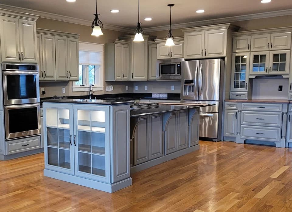 This is an image from Hernandez Painting, located in Tennessee. The photo displays a modern kitchen with gray cabinetry, stainless steel appliances, and polished wood flooring.