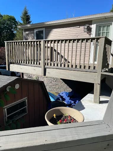 This is an image from Jay's Pro Painting, located in New York. The outdoor photo shows a weathered gray wooden deck with railings attached to a light-colored house.