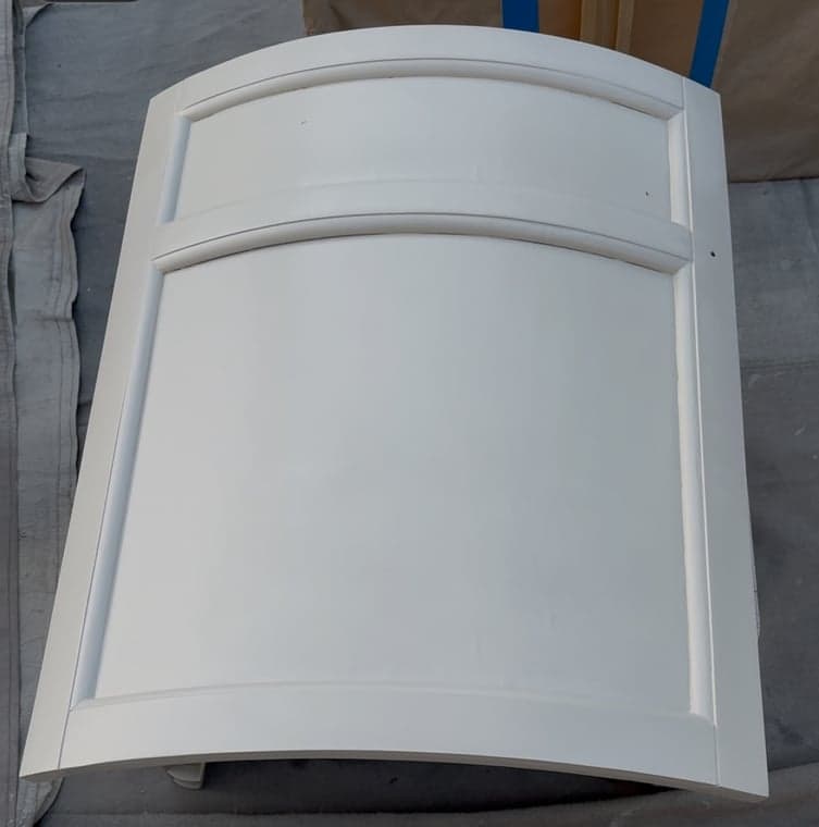 Light gray painted cabinet door featuring a traditional arched panel design.