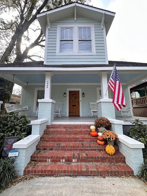 Porch painting project by GW Painting in Charlotte, NC. The image shows a white home entry with brick steps, columns, and front trim.