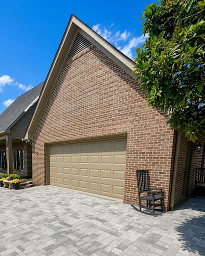 Painting work by McLain's Painting in Knoxville, Tennessee. The image shows a brick garage with a taupe painted door.