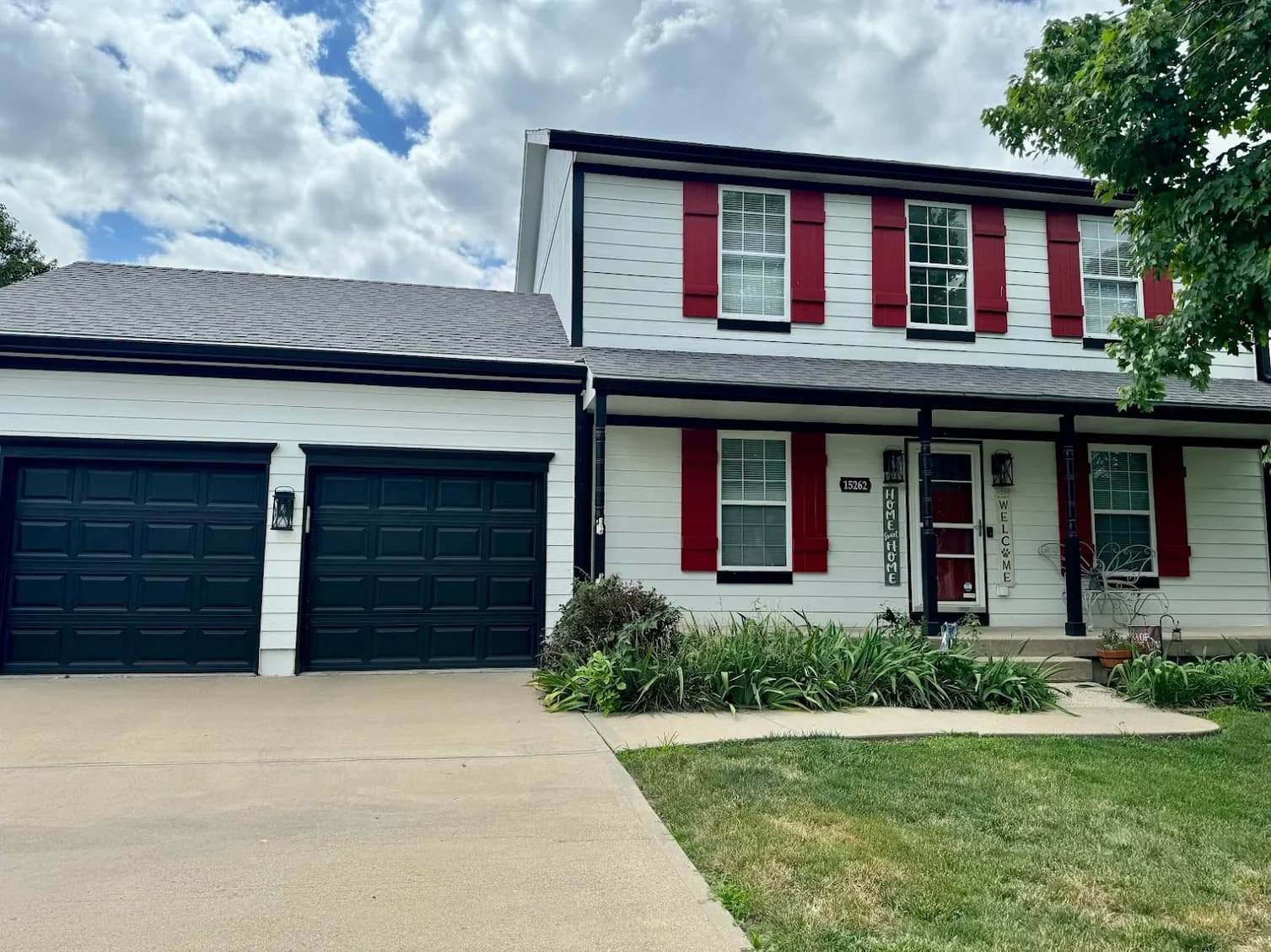 This is an image from Paint Pro Inc. The image is exterior home painting in Kansas City KS with gray stucco, white trim, and natural wood shutters.