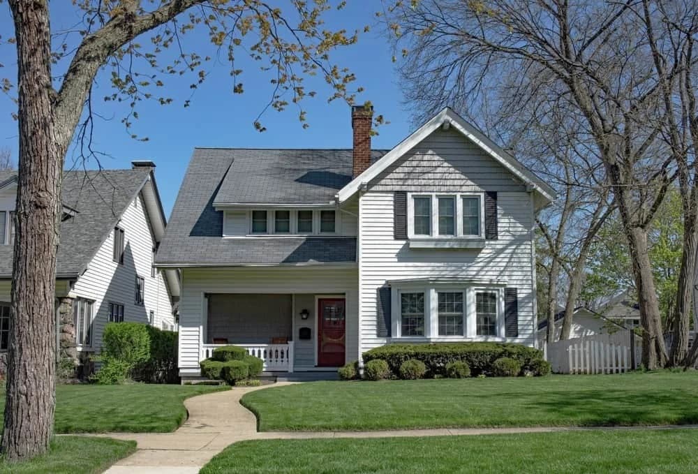 Rhino Shield of Chicagoland completed this Illinois exterior project. The image shows a white home with dark shutters and a red front door.