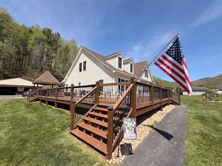 Deck staining by CertaPro Painters of Hickory in Hickory, NC. The image shows a large brown deck with railings, stairs, and an American flag.