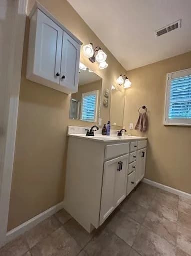 Painting work by Suzuki Painting in Whitesburg, Tennessee. The image shows a gray bathroom vanity with white fixtures.