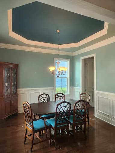 Interior painting project by CPM Painting INC in Raleigh, NC. The image shows a dining room with teal walls, a teal ceiling, and white trim.