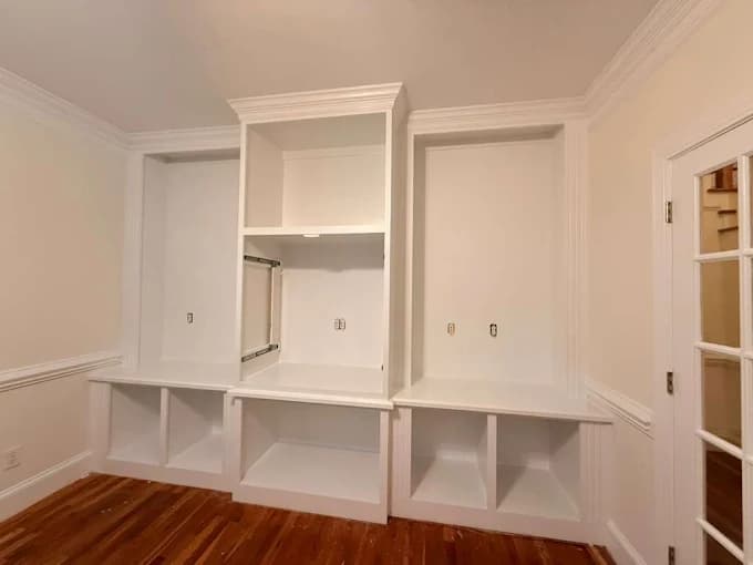 Interior painting project by Sanchez Painting and Home Improvement, LLC in Greenville, NC. The image shows white built-in shelving and cabinets.