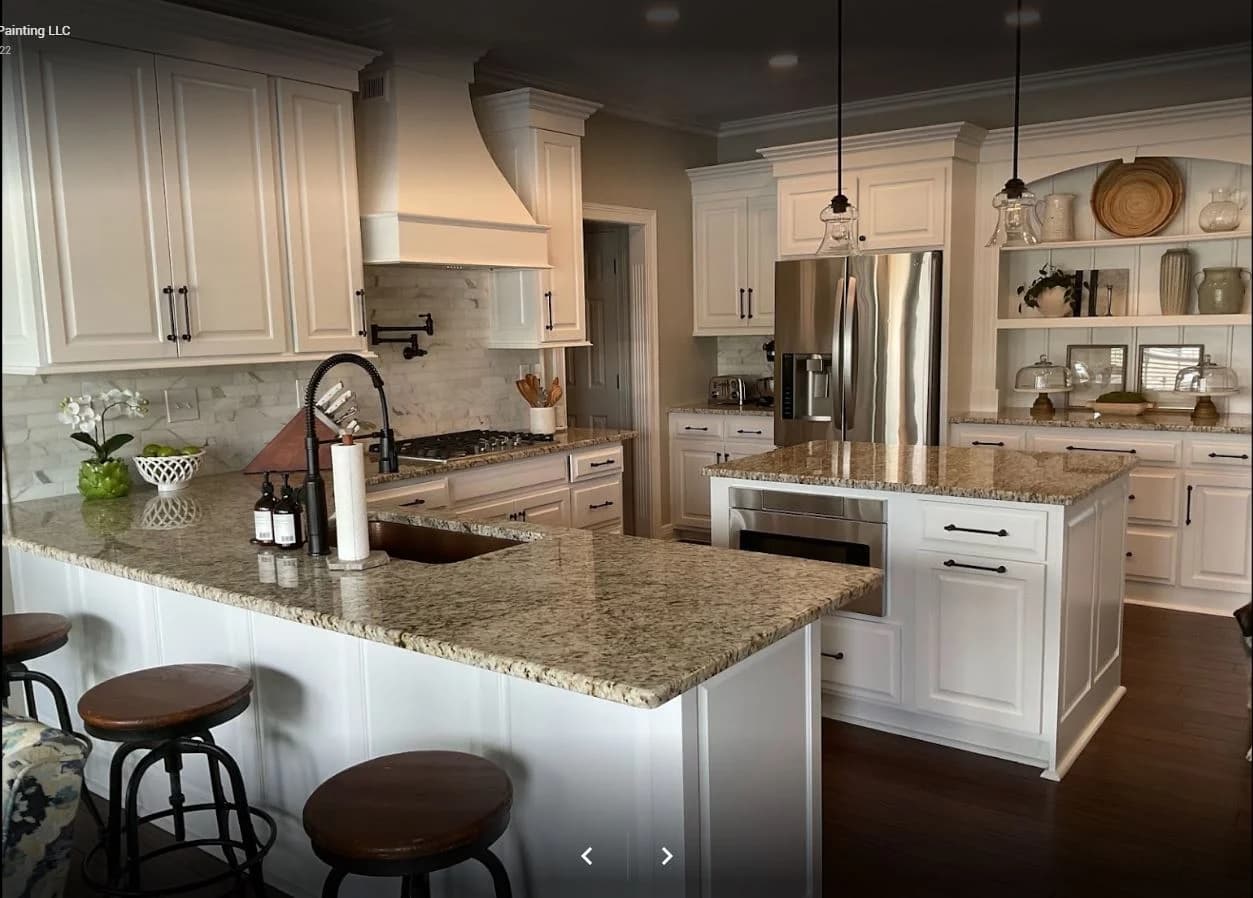 This is an image from Big J Painting LLC, located in Kentucky. The photo shows a modern kitchen with freshly painted white cabinetry, granite countertops, and stainless steel appliances for an elegant finish.
