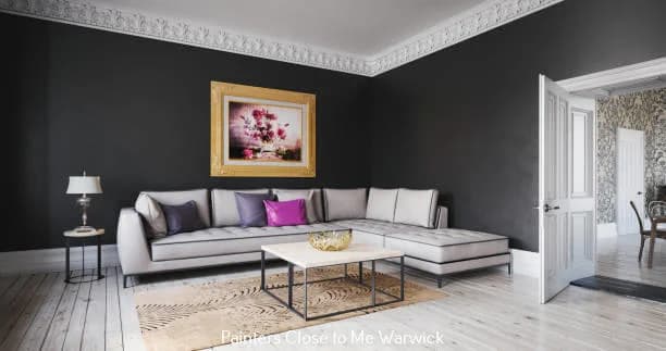This is an image from Willow Tree Painting & Home Improvement LLC, located in New York. The photo shows a living room with dark charcoal walls, white crown molding, a light sectional sofa, and a framed floral painting above the seating area.