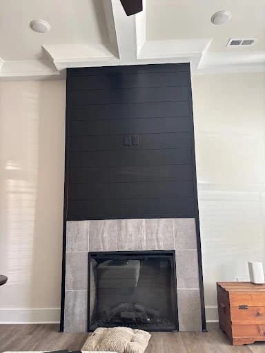 Ridgeline Pro Painters painting project in Chattanooga, Tennessee. The image shows a black fireplace accent wall beneath a vaulted ceiling.