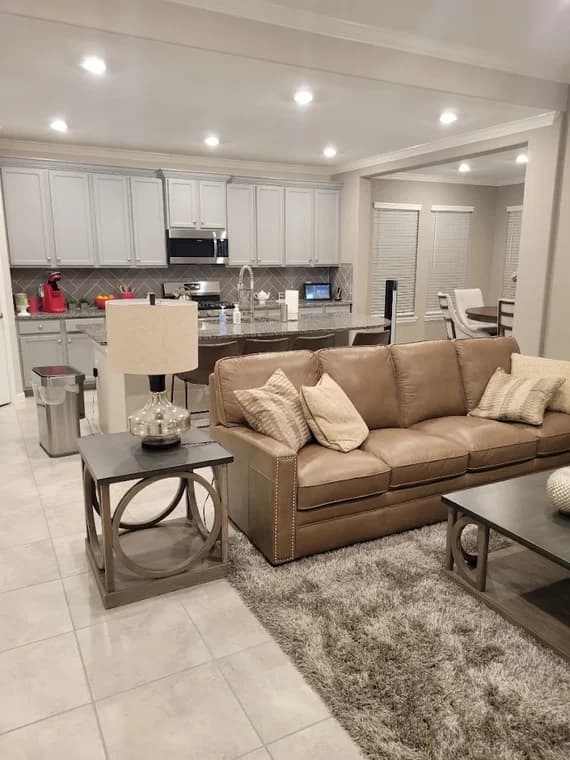 "This is an image from Perera Painting & Remodeling, located in Texas. The foyer features updated interior paint, wood flooring, white trim, and a wooden front door with decorative glass."