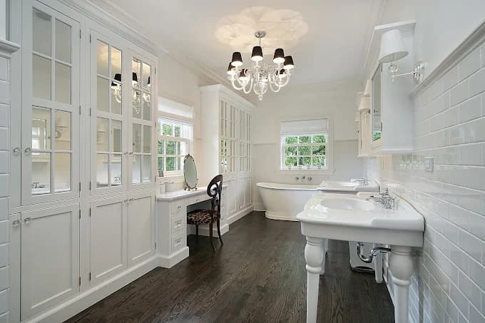 This is an image from Long Island Painting & Restoration Inc., located in New York. The bathroom features white painted built-in cabinets, dual sinks, and classic trim work that emphasize the refined interior paint job.