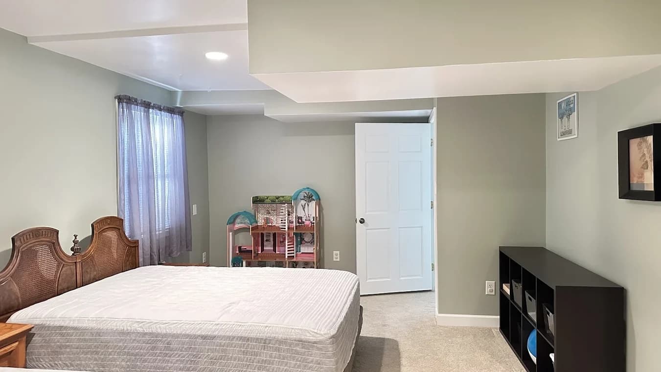 Interior painting project by Garcia's Painting & Repair NC, LLC in Chapel Hill, NC. The image shows gray-green bedroom walls, white doors, and a tray ceiling.