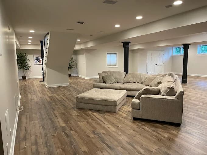 Interior painting by Dr Paint Inc Professional Painting in Homer Glen, Illinois. The image shows neutral walls, recessed lights, wood-look flooring, and black columns.