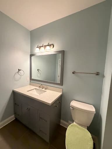 Painting work by Mike’s Painting in Oak Ridge, Tennessee. The image shows a gray bathroom with white fixtures.
