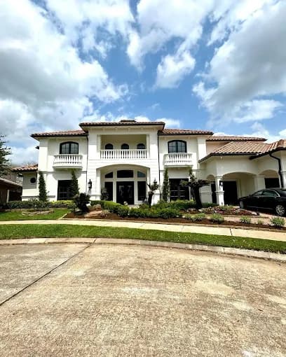 This is an image from DABS Painting, located in Texas. The image shows a large freshly painted two-story white stucco home with arched windows, balconies, and a landscaped front yard.