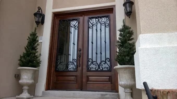 Painting project by Fresh Coat Painters of Clarksville in Clarksville, Tennessee. The image shows stained wooden double front doors.
