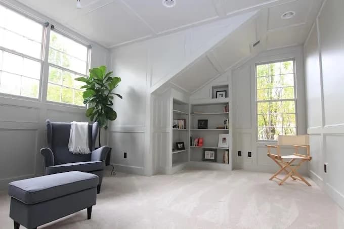 Interior painting by B Quality Painting LLC in Arlington, Tennessee. The image shows a bright loft with white walls, tall windows, and built-in shelves.