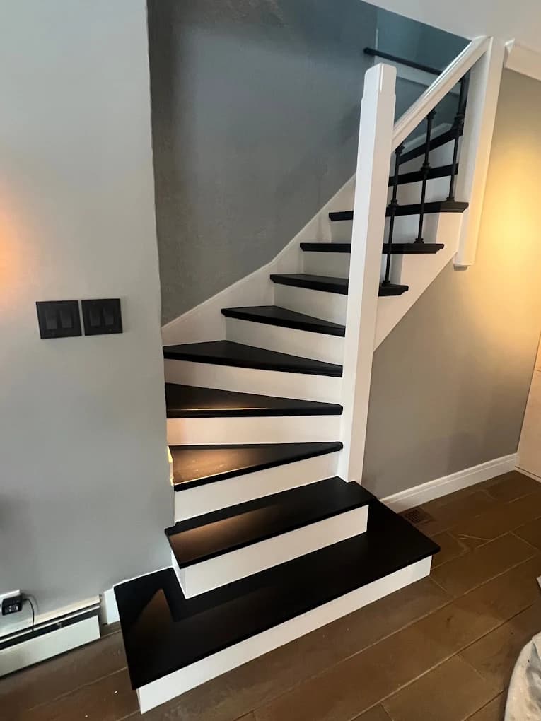 Red Sky Painting completed this Illinois interior project. The image shows black stair treads and railings, white risers and trim, and gray walls.