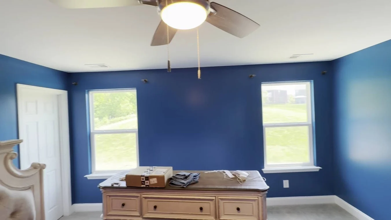 Covenant Painting Services painting project in Gallatin, Tennessee. The image shows a bedroom finished with deep blue walls and white trim.