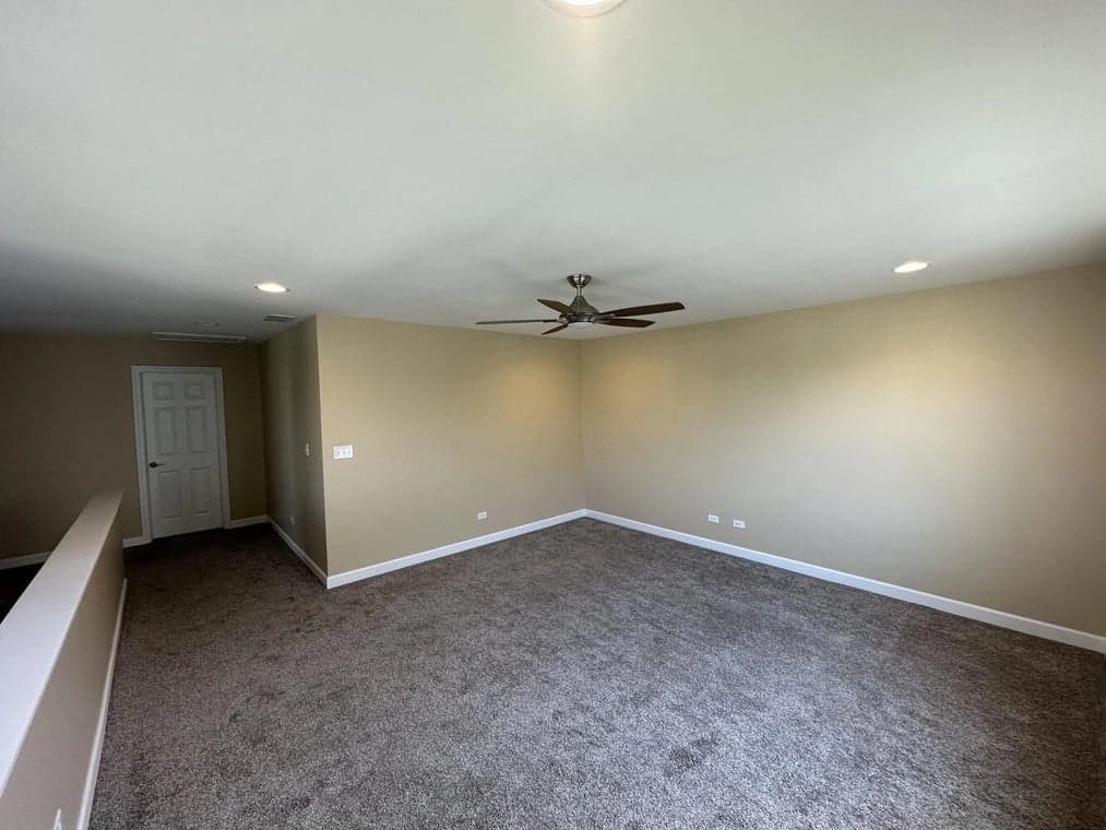 Interior painting by Slaviks Painting & Decorating in Wood Dale, IL. The image shows a beige room with white trim and carpet.