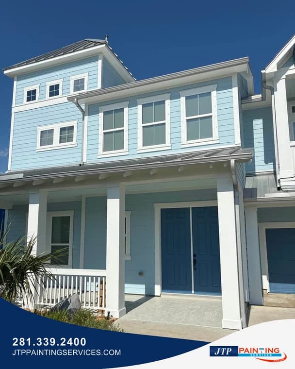 This is an image from JTP Painting Services, located in Texas. The exterior of a light blue coastal-style home is shown with white trim, updated paint, and a freshly coated entry door.
