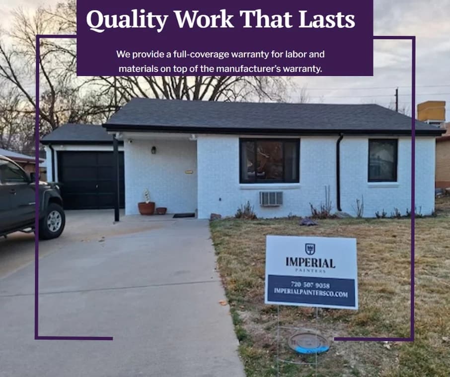 This is an image from Imperial Painters Company, located in Denver, CO The image is an Imperial Painters yard sign in front of a freshly painted white brick home with black trim, promoting quality residential painting services with full warranty in Denver, Colorado.