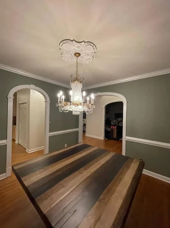 Painting work by Oak City Coatings in Raleigh, North Carolina. The image shows a gray dining room with white trim and wood flooring.