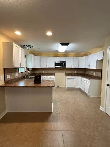 Painting work by Suzuki Painting in Whitesburg, Tennessee. The image shows a bright white kitchen with stainless appliances.