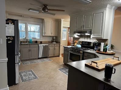 Kitchen painting project by CertaPro Painters of Fayetteville, NC in Lillington, NC. The image shows tan cabinets, a dark island, and a range.