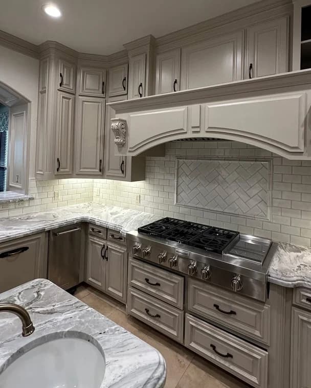 This is an image from Alliance Painting, located in Texas. The kitchen features freshly painted cabinetry in a soft neutral tone with detailed trim and modern hardware.