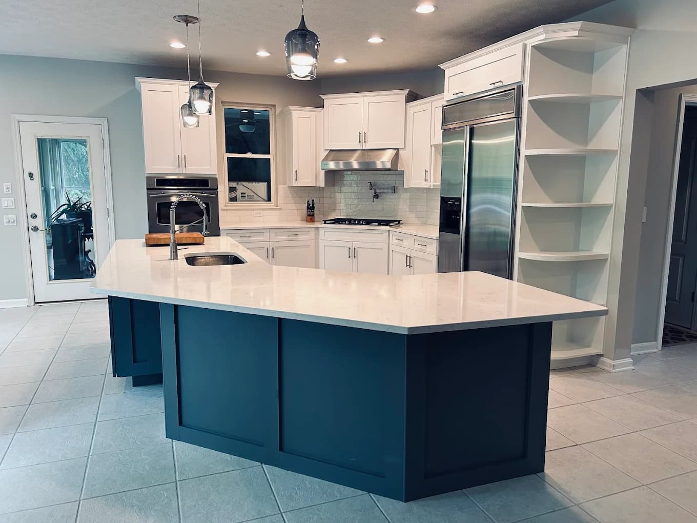 Cabinet painting by Joyful Cabinet Painting in Cincinnati, Ohio. The image shows white cabinets and a blue kitchen island.