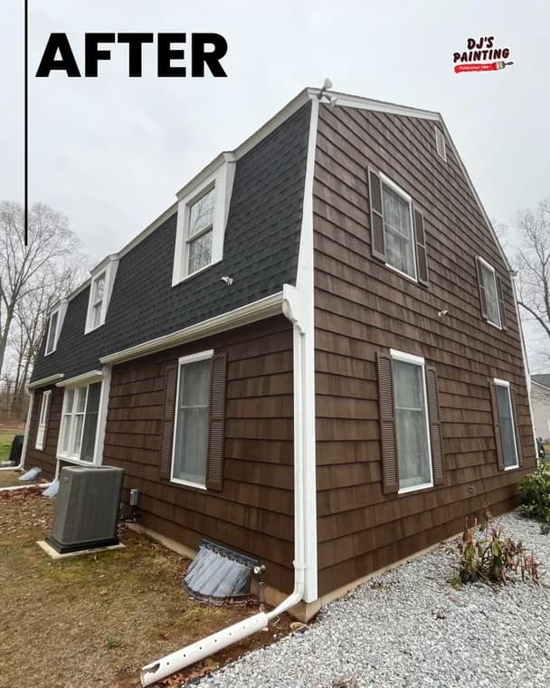 This image features the finished exterior of a home painted by DJ's Painting. The siding is a rich brown color with black shingle details and white trim, giving the house a refreshed and polished look.