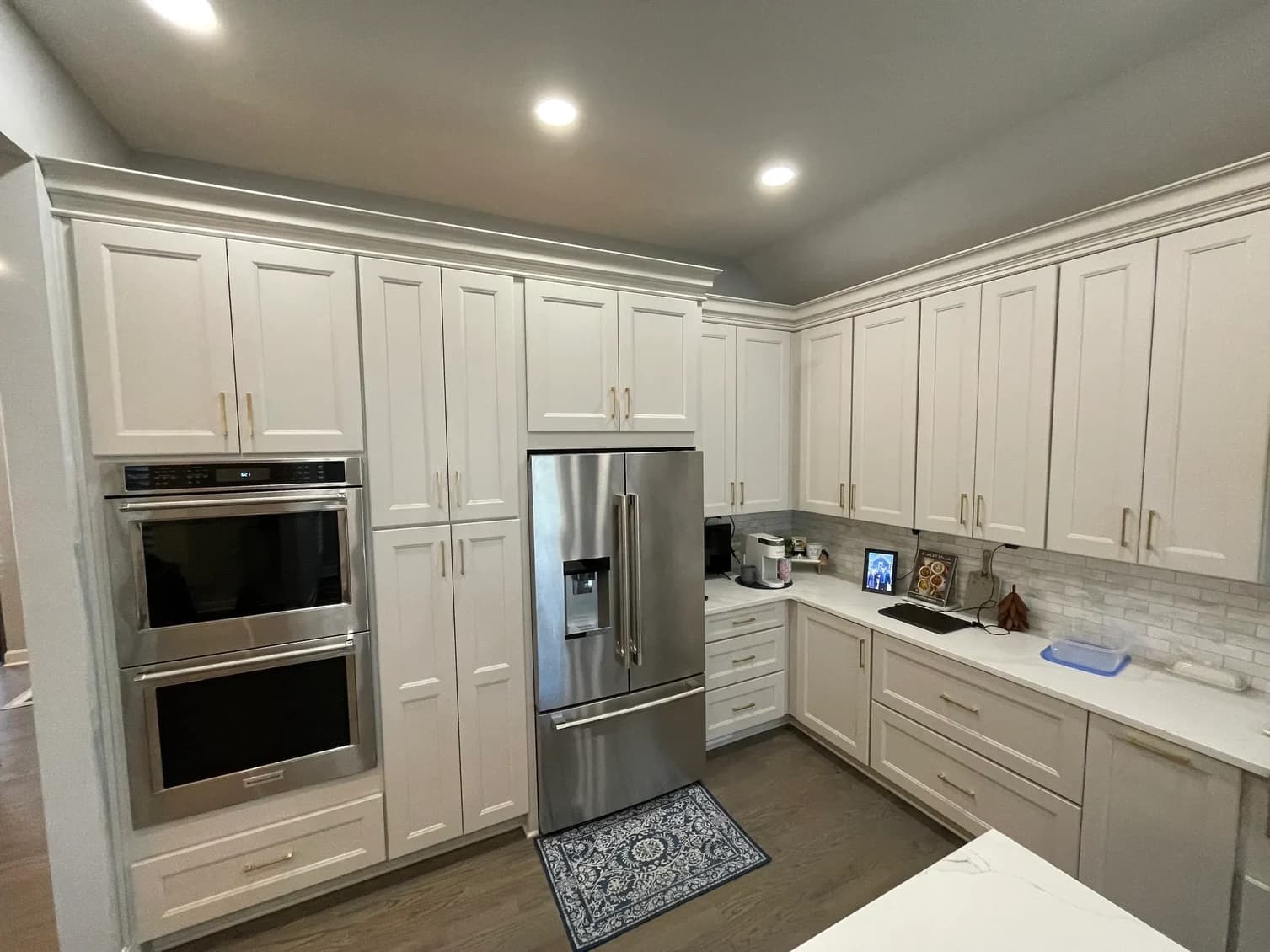 This is an image from KC Sharp Co. The image shows the exterior side of a house painted in a solid medium-gray color with white trim accents.
