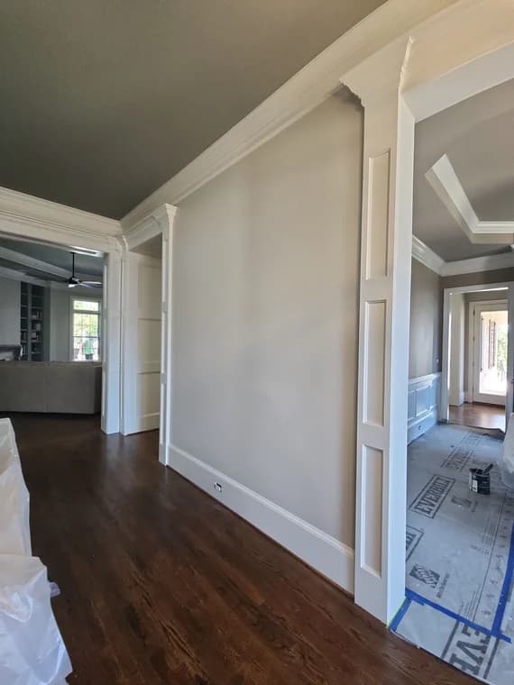 This is an image from A Cut Above Painting Co. company, located in Evans, GA The image is a freshly painted interior hallway with light gray walls, white trim, and crown molding by A Cut Above Painting Co.
