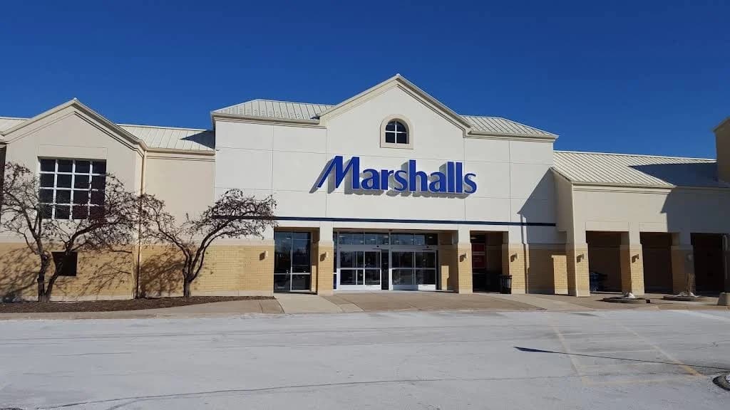 Commercial stucco project by JJ Stucco & Plastering System Inc. in Lake in the Hills, Illinois. The image shows a beige retail facade with white trim and blue signage.