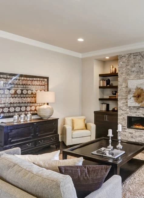 This is an image from 360 Painting of Wichita. The image shows a living room with smooth, newly painted neutral walls that complement the stone fireplace and built-ins.
