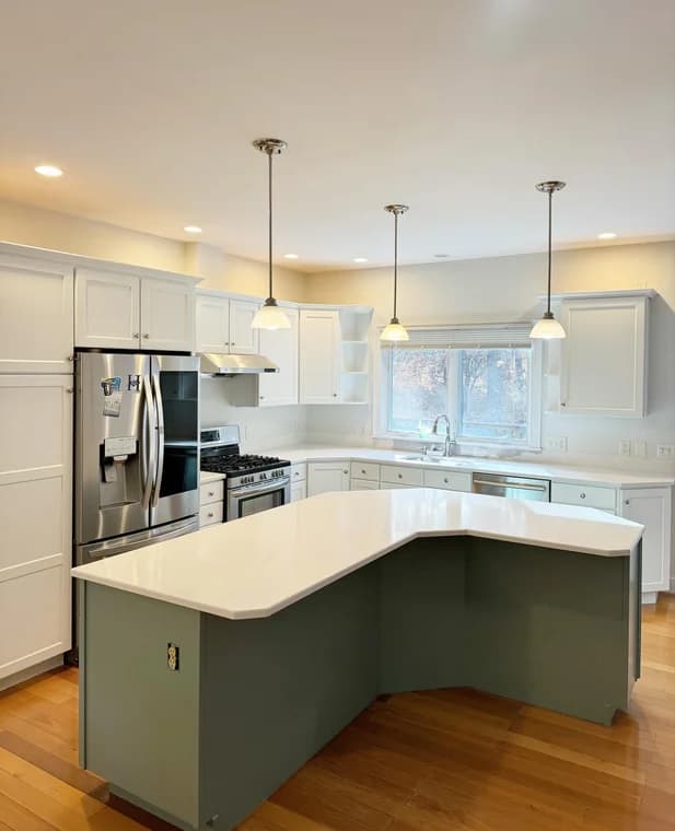 Kitchen refinishing project by Cape Cod Fine Finishes LLC. The space features white cabinetry, stainless steel appliances, and a central island with a modern green base.