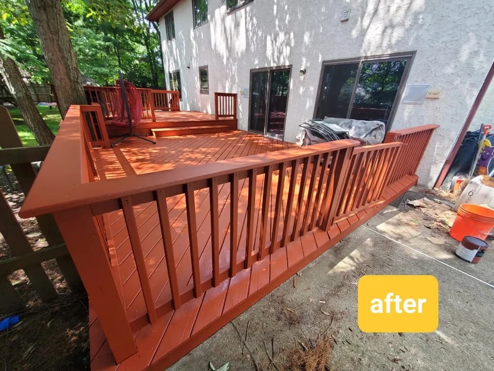 Freshly stained wooden deck with a rich reddish-brown finish, completed by Four Golden Brothers Painting.