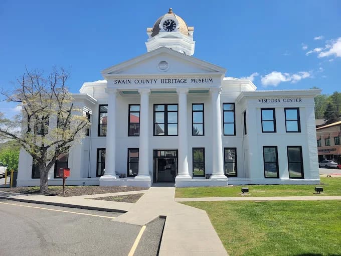 Commercial exterior painting project by Huskey's Paint & Design in Sylva, NC. The image shows a white building with columns, black window trim, and a clock tower.