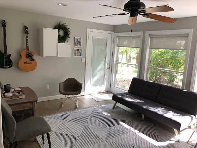 Painting by Men In White Painting LLC in Mt Vernon, IL. The image shows a gray living room with white trim and large windows.