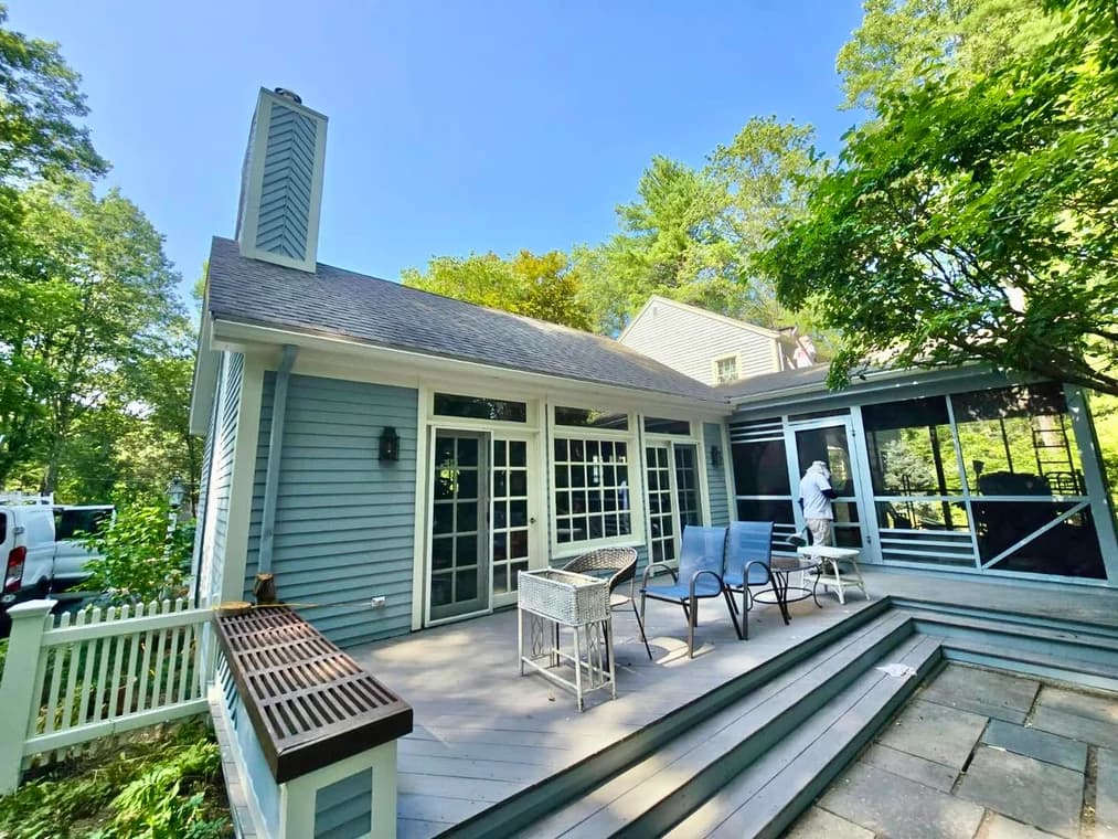This is an image from Right Track Painting & Sealcoating, showing the exterior of a gray home with a large deck. Fresh paint and clean lines on the siding and deck highlight the professional quality of the work.