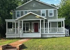 Exterior painting project by Roca's Painters LLC in Mebane, North Carolina. The image shows a sage green two-story home with white trim and a red front door.
