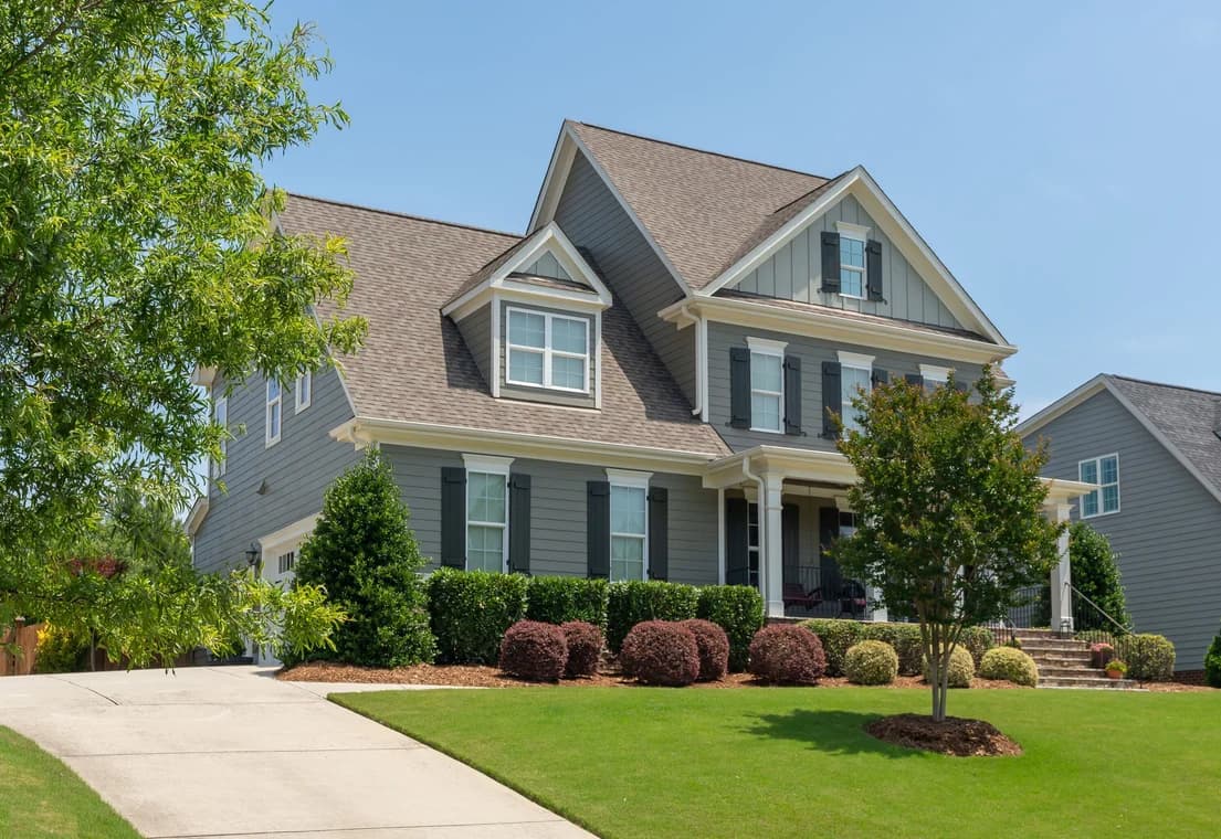 Painting work by Oak City Coatings in Raleigh, North Carolina. The image shows a gray house exterior with white trim.