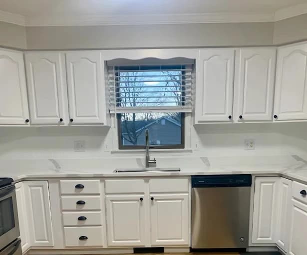 Painting by Men In White Painting LLC in Mt Vernon, IL. The image shows a white painted kitchen with dark hardware.