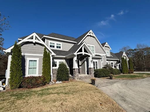 Ridgeline Pro Painters painting project in Chattanooga, Tennessee. The image shows a green stone-and-stucco home with white trim.